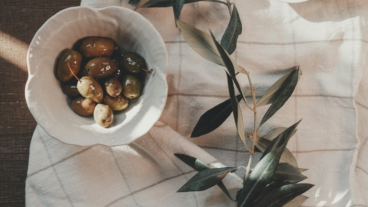 Mesa de otoño mediterránea con aceitunas y ramas de olivo - Pino & Jacaranda