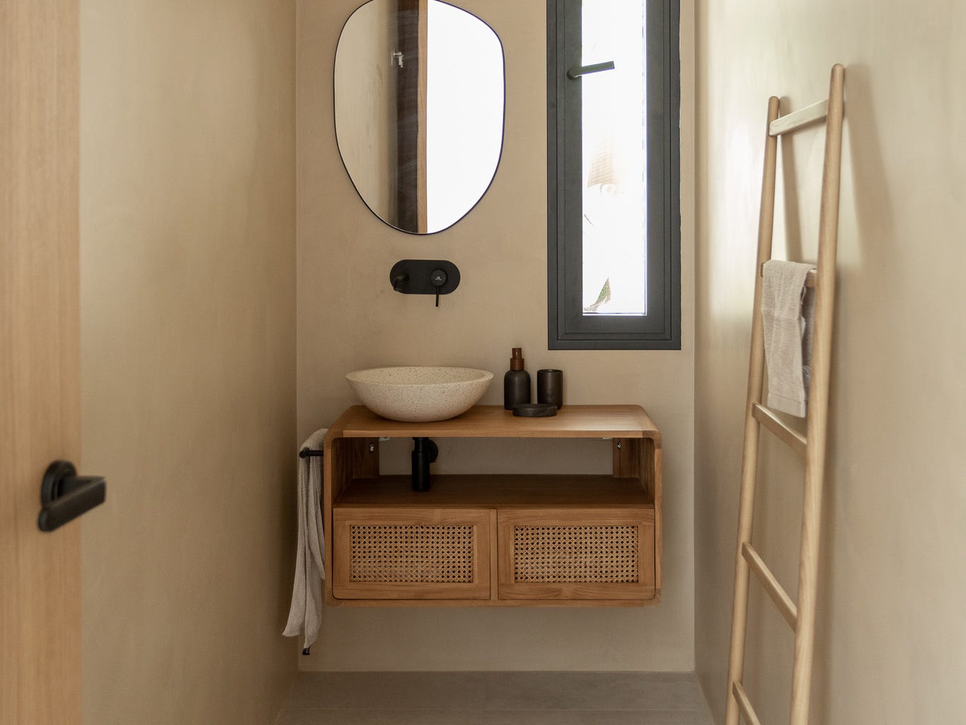 Baño de estilo mediterráneo con mueble bajolavabo de madera y ratán