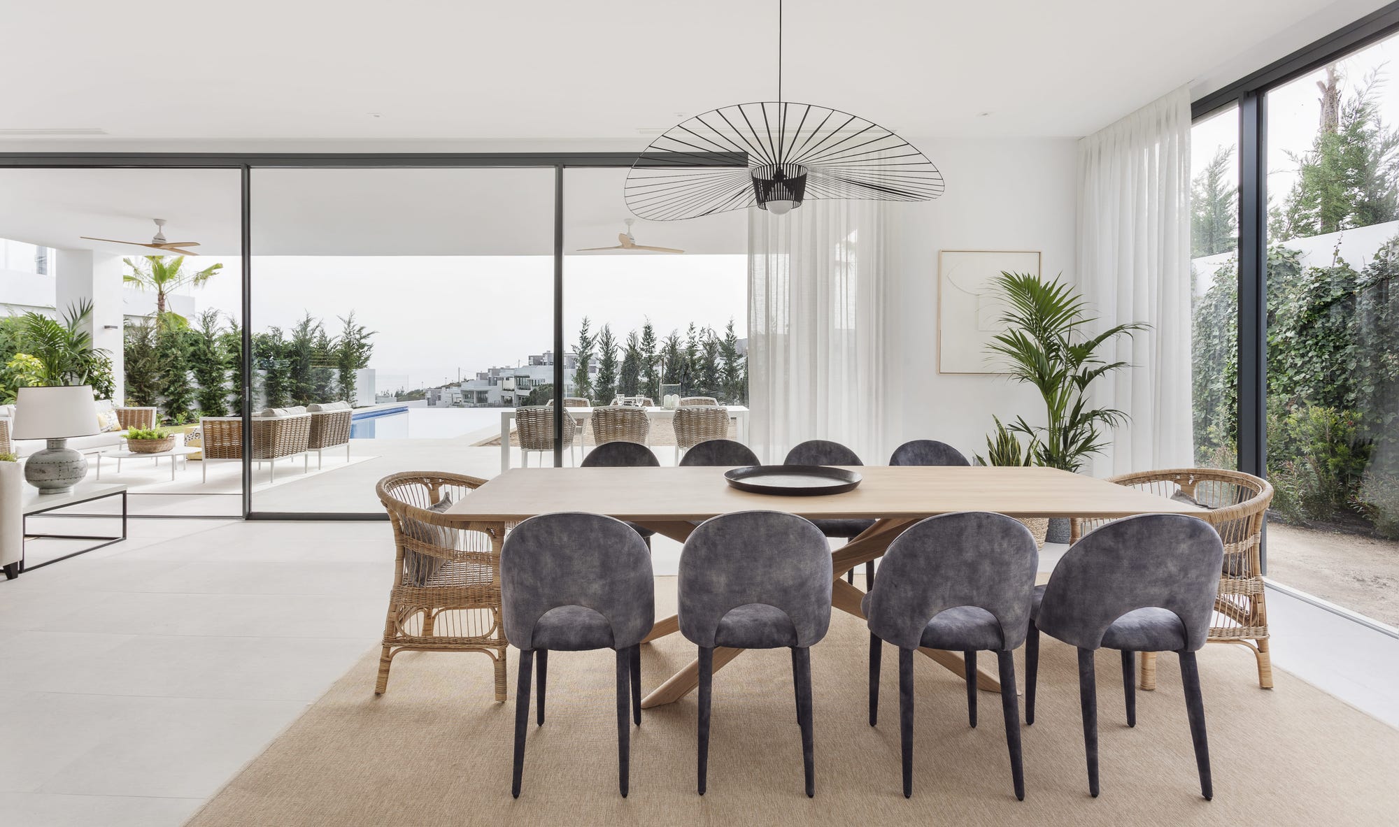 Comedor de estilo mediterráneo con mesa de madera abierto al porche en una casa de Marbella