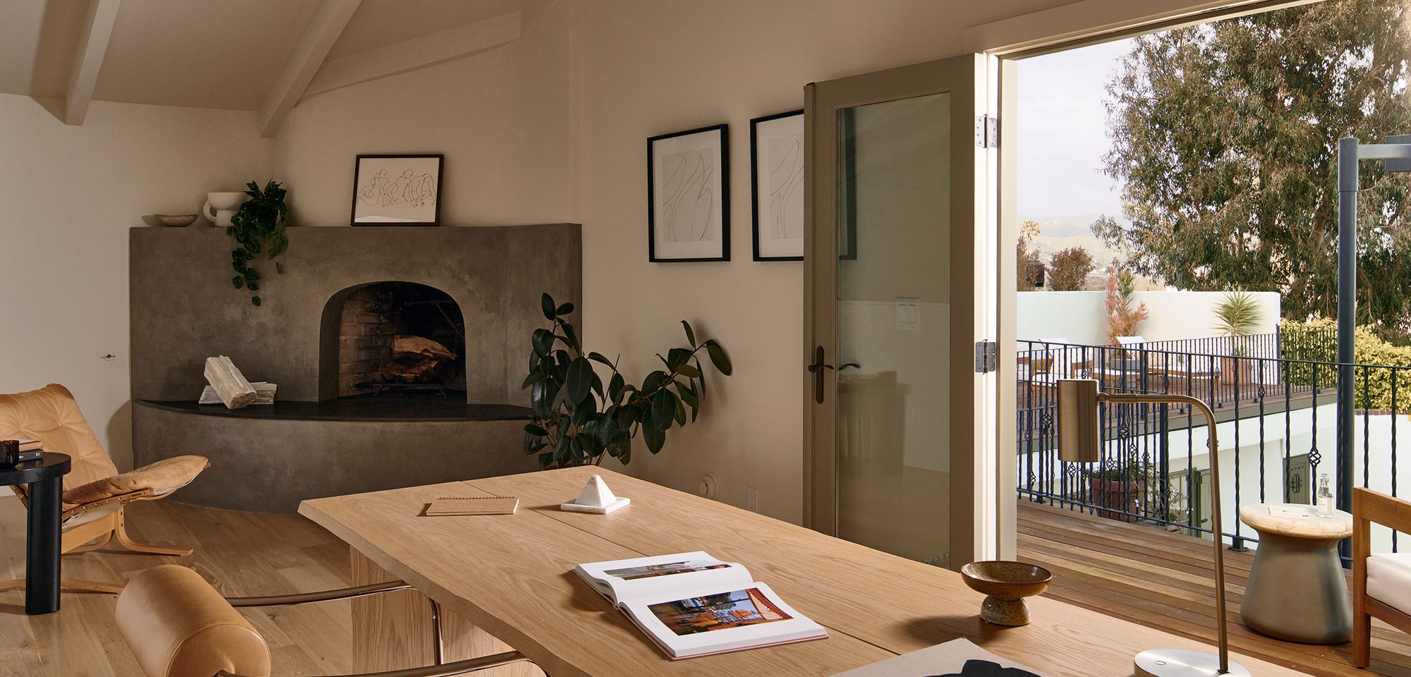 Despacho en casa con escritorio de madera maciza, chimenea de obra y salida a la terraza