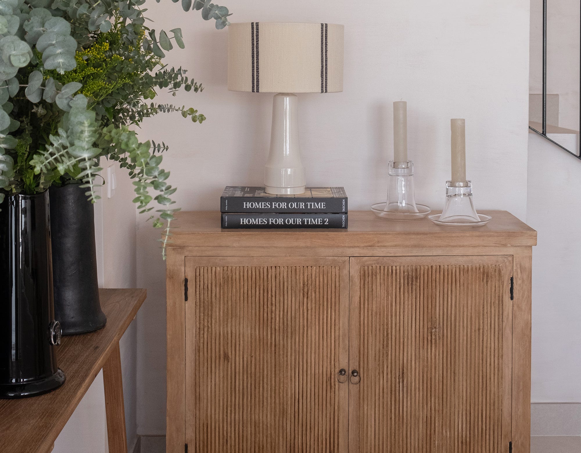 Aparador de madera con lámpara de mesa de cerámica y pantalla tejida en una casa de Sancti Petri