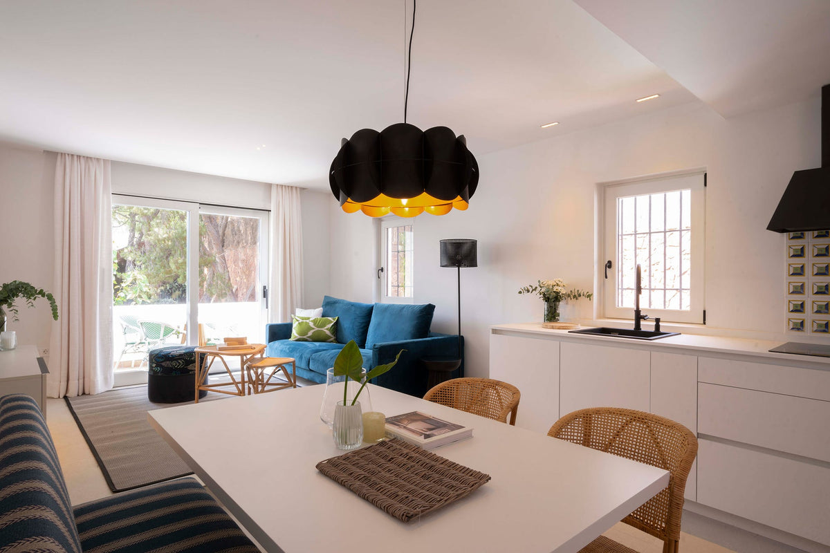 Salón con cocina y comedor de estilo mediterráneo en una casa tradicional rehabilitada en Málaga